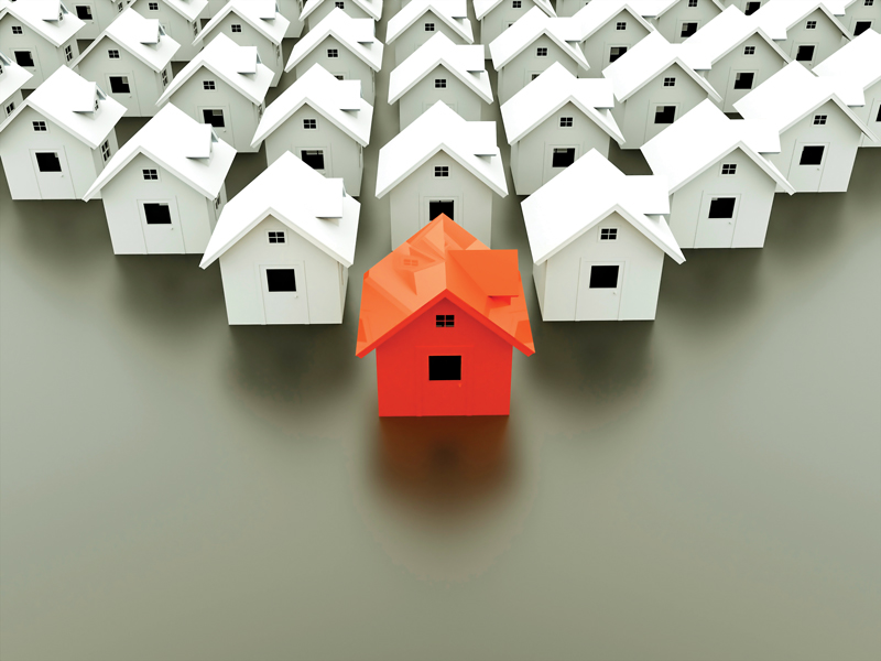 Une maison rouge entourée de plusieurs maisons blanches.