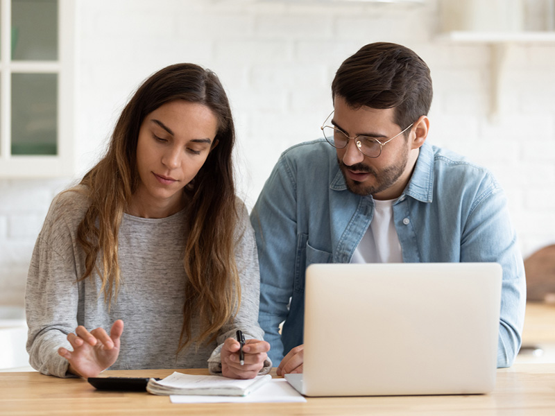 Jeune couple travaillant à l'ordinateur.