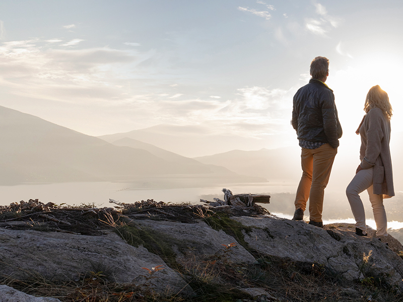 Couple debout fièrement au sommet de la montagne