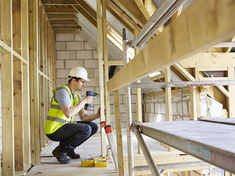 Employé de la construction s'affairant sur une structure.