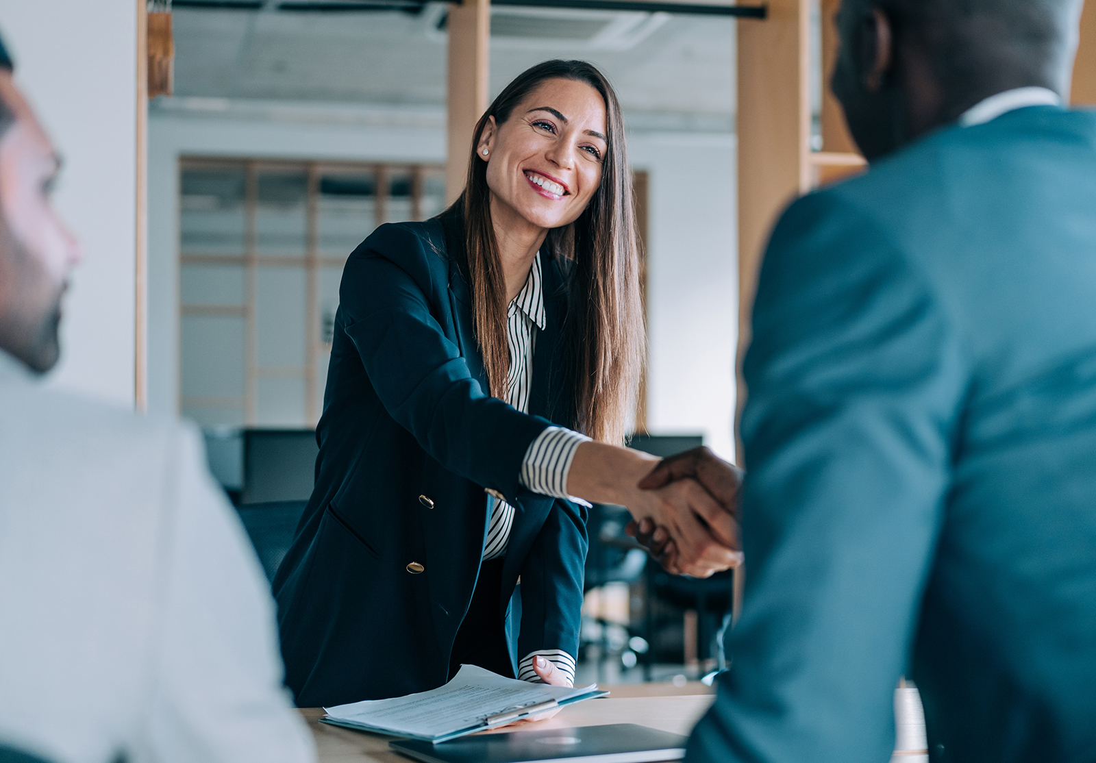 Des hommes d'affaires se serrent la main au bureau. Groupe d'hommes d'affaires en réunion. Trois entrepreneurs en réunion dans une salle de réunion. Équipe d'entreprise en réunion dans un bureau moderne. Femme cadre discutant d'un nouveau projet avec ses collègues. Chef d'entreprise en réunion avec deux de ses employés dans son bureau.