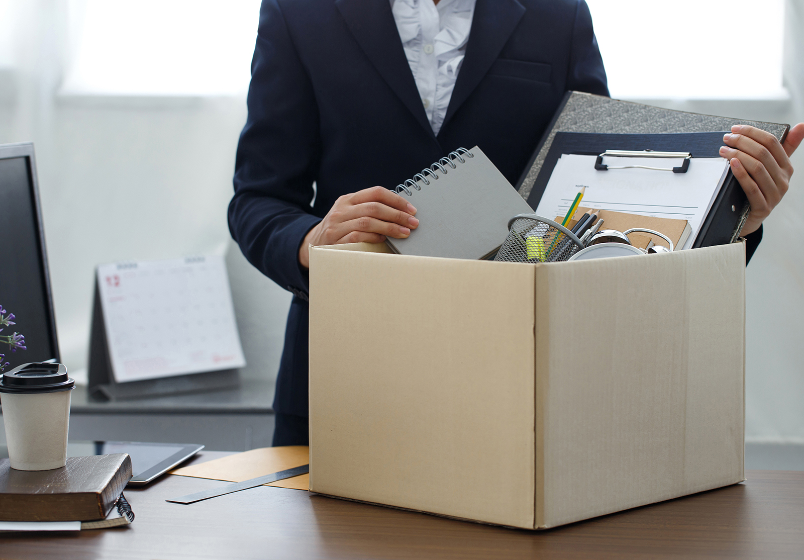 Une femme d'affaires emballe les effets personnels de son entreprise lorsqu'elle décide de démissionner, de changer d'emploi ou d'être licenciée.