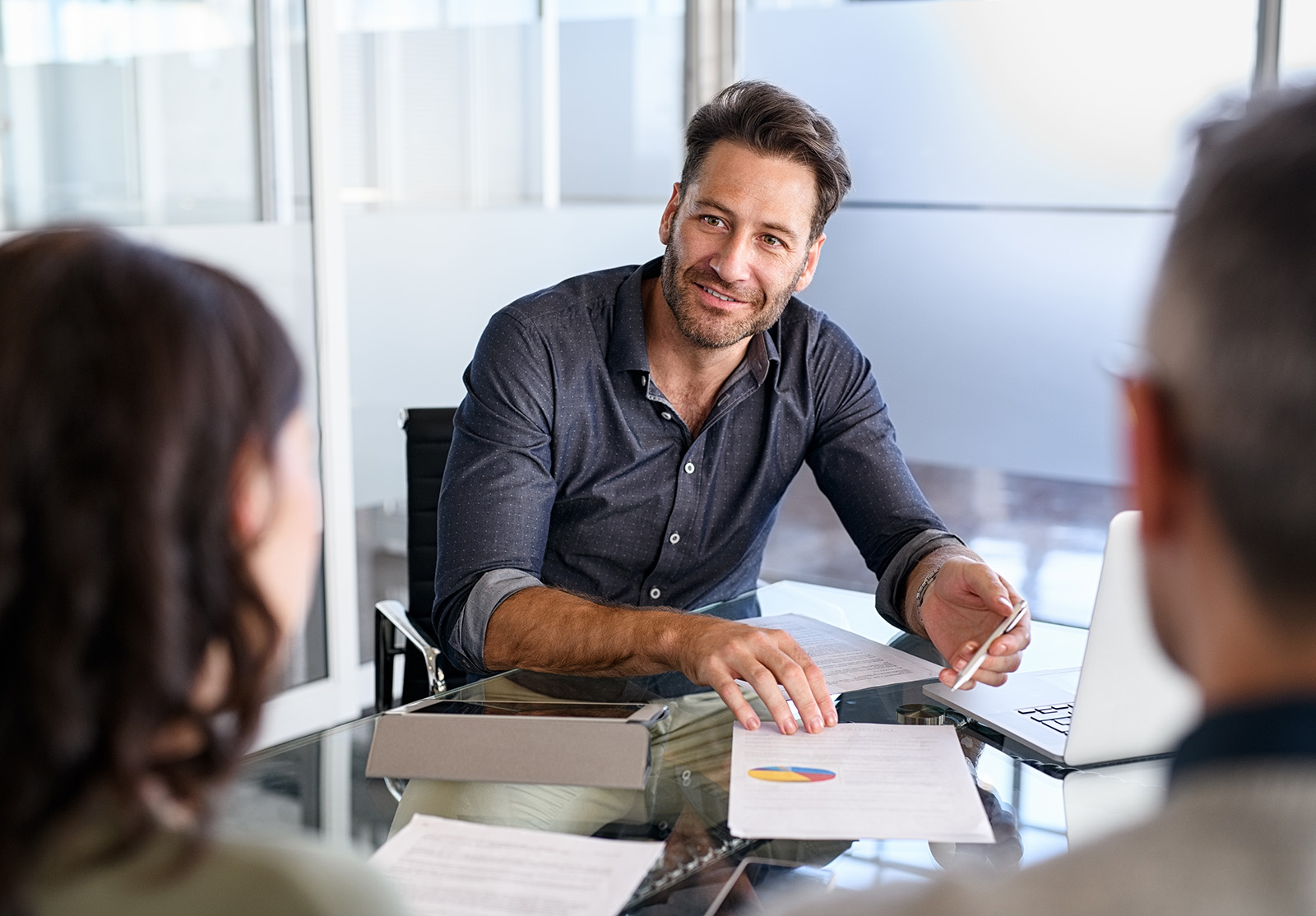 Agent financier d'âge mûr en réunion avec un couple d'adultes d'âge mûr pour leur proposer un nouvel investissement. Conseiller heureux discutant avec un homme et une femme de leur plan d'épargne. Conseiller en assurance en réunion avec un couple marié qui demande un prêt hypothécaire.