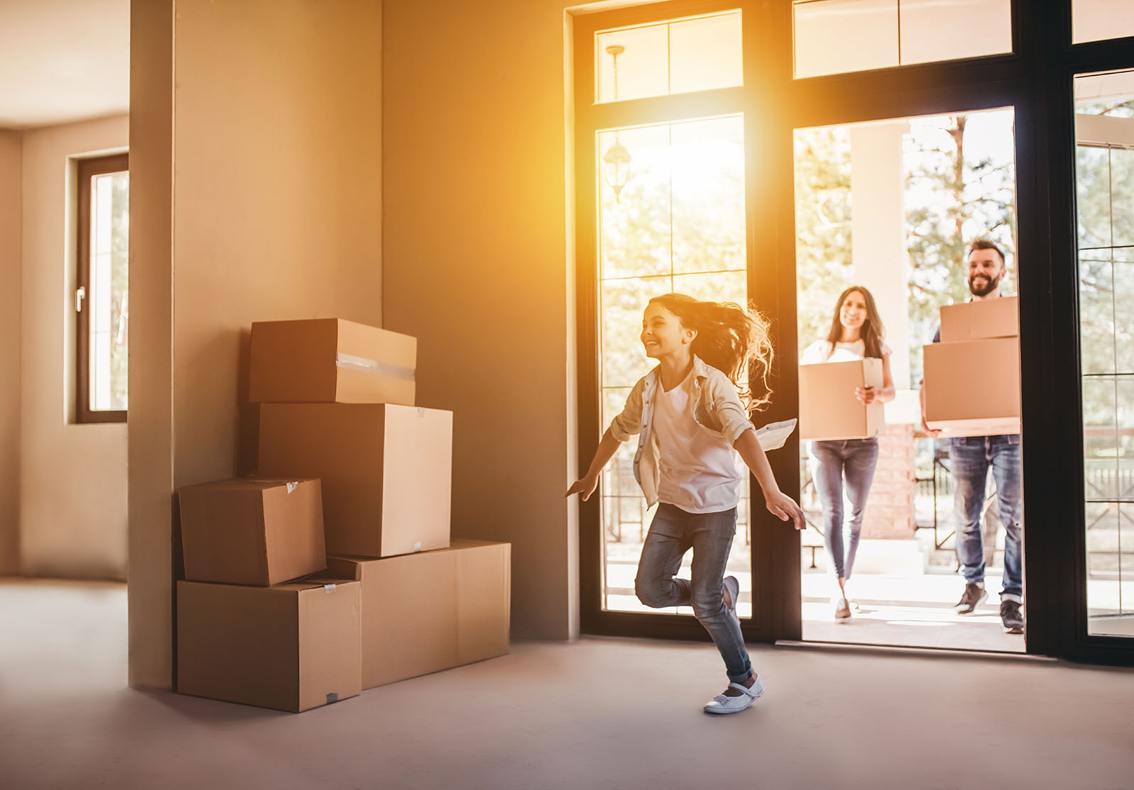 Une famille heureuse avec des cartons dans une nouvelle maison le jour du déménagement.