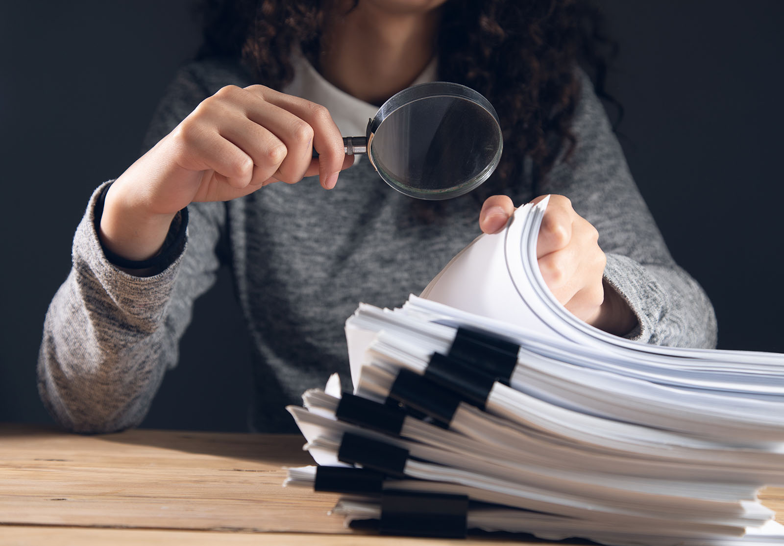 femme d'affaires tenant une loupe et des documents